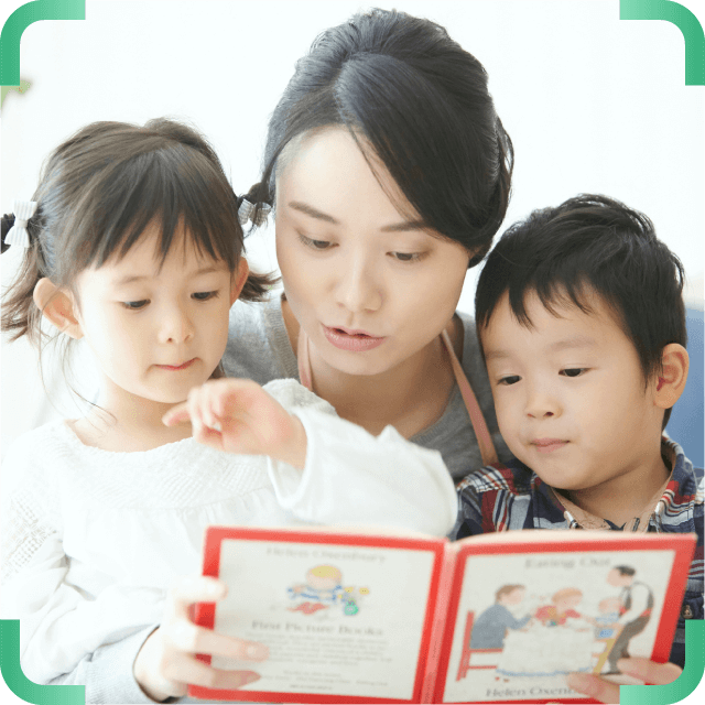 本を読む保育士と子供たち