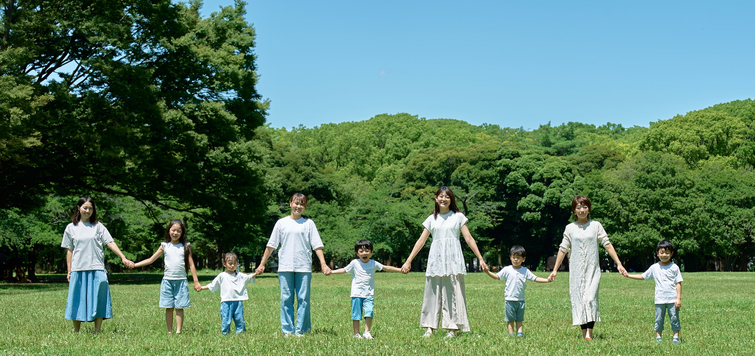 野原で一列に並ぶ親子